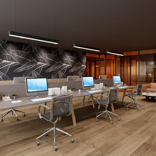 Modernes Büroarbeitsplatz-Design mit mehreren Arbeitsstationen ausgestattet mit iMac-Computern. Die Schreibtische sind aus hellem Holz und werden von ergonomischen Stühlen begleitet. Eine auffällige Wand mit großformatigem Blattmuster verleiht dem Raum einen künstlerischen Touch. Im Hintergrund ist eine entspannte Lounge-Ecke mit einem langen, braunen Ledersofa zu sehen, getrennt durch gläserne Trennwände, die den Raum offen und einladend gestalten.